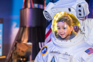 Boy in an astronaut suit in the Space Discovery Zone at WonderWorks Orlando